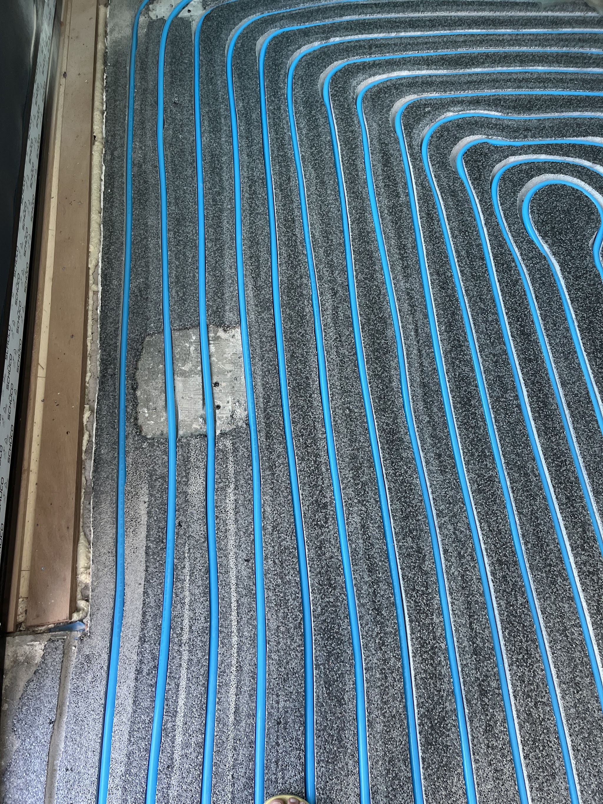 Blauwe leidingen gefreesd in een korreltapijtvloer, een klus die andere bedrijven niet aandurfden