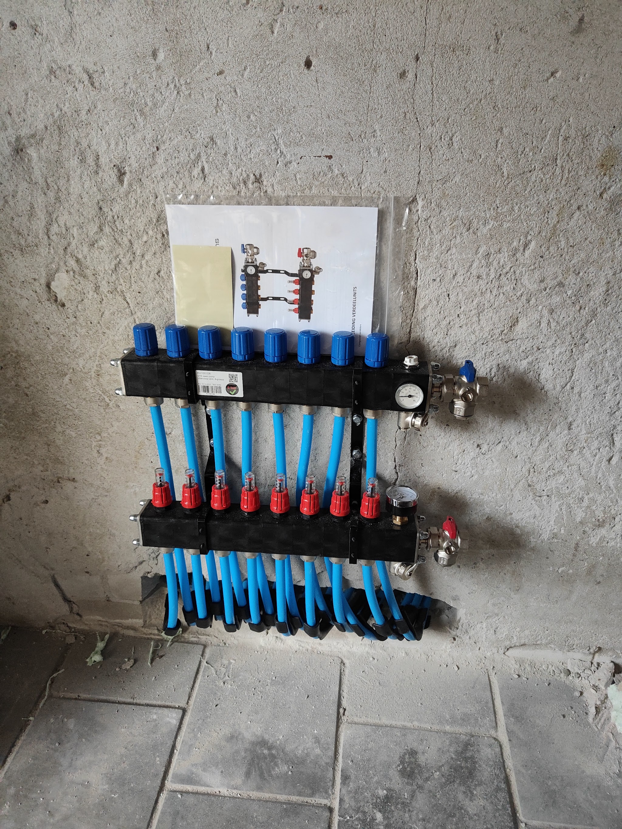 Nieuwe compacte verdeler met rode en blauwe groepen aan de wand